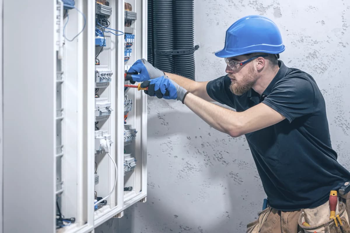 Electrician working in an open distribution board