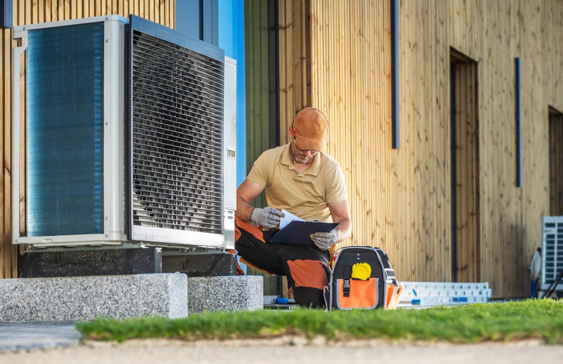 Buitenunit van een warmtepomp naast een Nederlandse woning