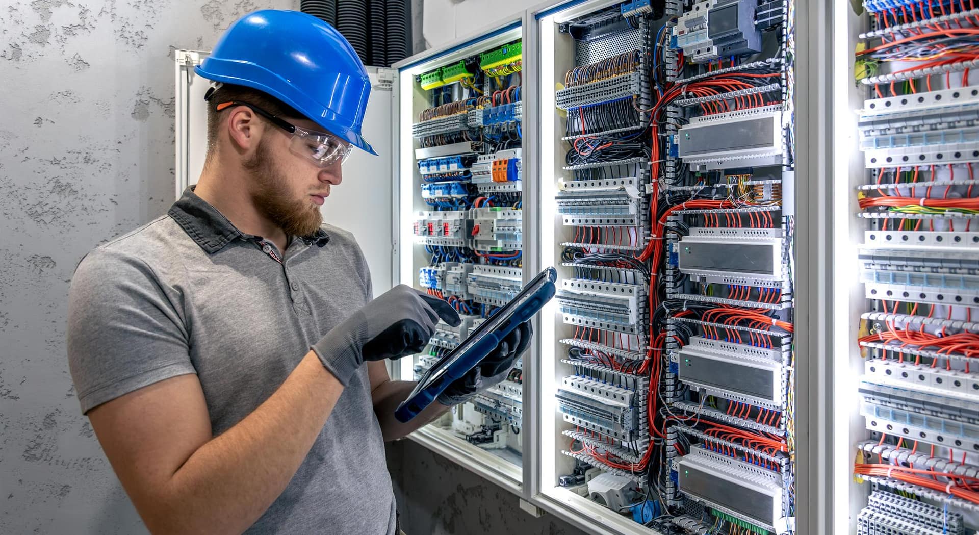 Installateur commissioneert een installatie met laptop bij een elektrische verdeelkast
