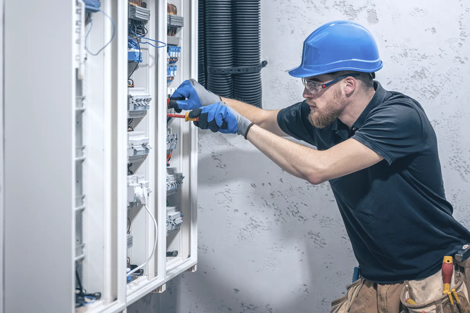 Electrician at work in an open distribution board
